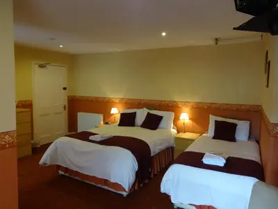 a hotel room with two beds and two lamps at Dumfries Villa in Dumfries