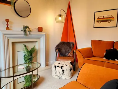 a living room with orange furniture and an orange umbrella at Carvetii - Phoenix House - Near Hospital, max 8 ppl in Carlisle
