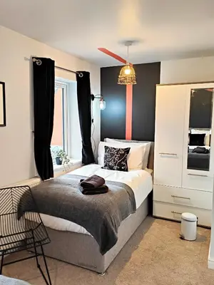 a bedroom with a large bed and a window at Carvetii - Phoenix House - Near Hospital, max 8 ppl in Carlisle