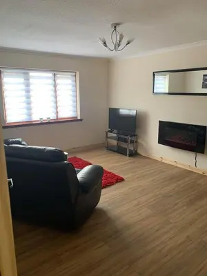 a living room with a couch and a flat screen tv at Flat 18 in Dumfries