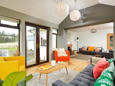 a living room with couches and a table at Borgan Cottage in Newton Stewart