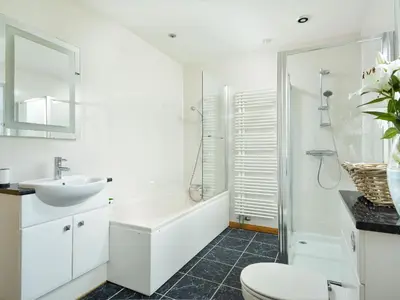 a white bathroom with a sink and a toilet at Borgan Cottage in Newton Stewart
