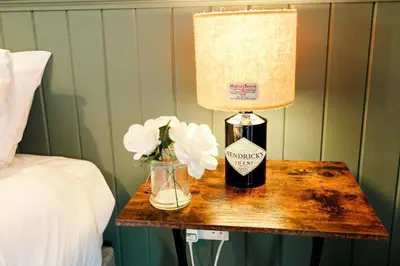 a table with a bottle of wine and flowers on it at Beth's Bothy in Gatehouse of Fleet