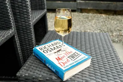 a book and a glass of wine on a table at Beth's Bothy in Gatehouse of Fleet