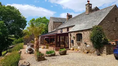 an old stone house with a conservatory in front of it at The Big 