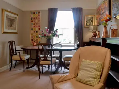 a dining room with a table and chairs and a window at Culpee House in Newton Stewart