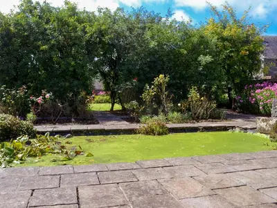 a garden with green grass and trees and bushes at Culpee House in Newton Stewart