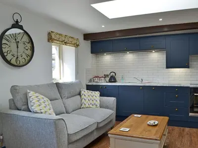 a living room with a couch and a clock on the wall at The Dairy - Uk30867 in St Bees