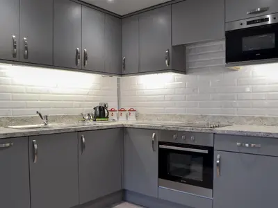 a kitchen with gray cabinets and stainless steel appliances at The Milking Parlour - Uk30866 in St Bees