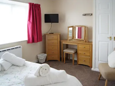 a bedroom with a bed and a dresser with a mirror at The Coach House - Uk30813 in Braithwaite