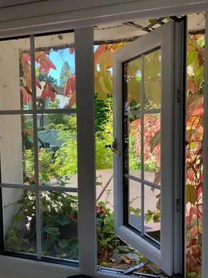a sliding glass door looking out at a garden at Marys Cottage, Grasmere, Dog Friendly, Hot Tub in Grasmere