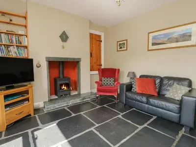 a living room with a couch and a fire place at Acorn Cottage in Coniston
