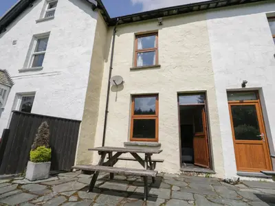 a picnic table in front of a house at Acorn Cottage in Coniston