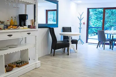 a kitchen and dining room with a table and chairs at Tholt-y-Will B&B in Sulby