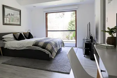 a bedroom with a bed and a large window at Tholt-y-Will B&B in Sulby
