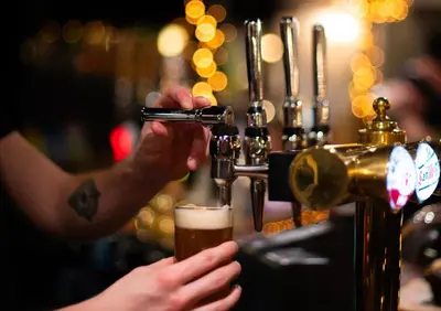 a person drinking a beer at a bar at Buttermere Court Hotel in Buttermere