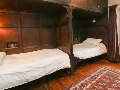 two bunk beds in a room with wooden walls at The Pend in Newton Stewart