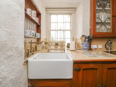 a kitchen with a white sink and a window at The Pend in Newton Stewart