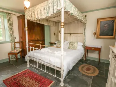 a bedroom with a four poster canopy bed at Faldarroch Farm in Newton Stewart