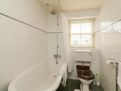 a white bathroom with a tub and a toilet at Faldarroch Farm in Newton Stewart