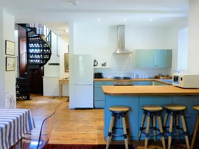 a kitchen with blue cabinets and a counter with stools at The Royal Apartment - Uk31086 in Portpatrick