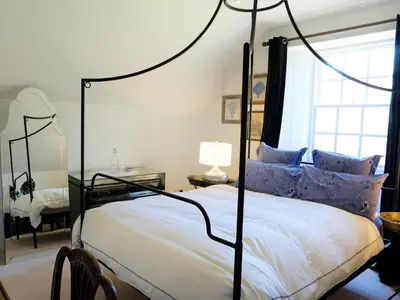 a bedroom with a black canopy bed with blue pillows at The Royal Apartment - Uk31086 in Portpatrick