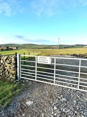a fence with a sign on it next to a field at Ardbeg 4 - Farm Stay with Sea Views across to Northern Ireland in Stranraer
