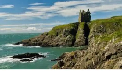 a castle on top of a cliff near the ocean at Ardbeg 4 - Farm Stay with Sea Views across to Northern Ireland in Stranraer