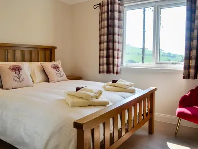 a bedroom with a large bed with towels on it at Auchen Ladder in Amisfield Town