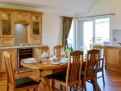 a dining room with a wooden table and chairs at Auchen Ladder in Amisfield Town
