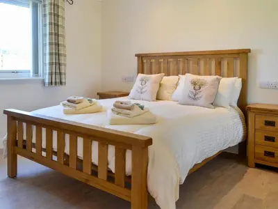 a bedroom with a large bed with towels on it at Auchen Ladder in Amisfield Town