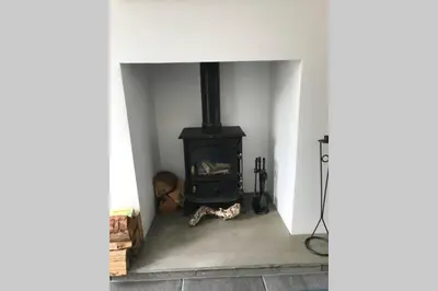 a dog laying in front of a stove in a room at Albion Cottage in Cockermouth