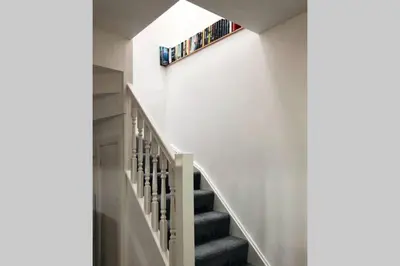 a staircase in a house with a shelf on the wall at Albion Cottage in Cockermouth