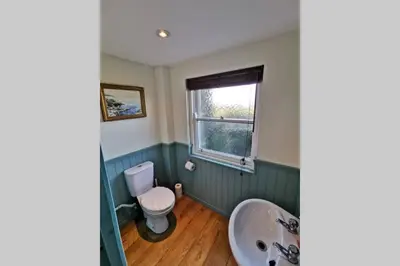 a bathroom with a toilet and a sink at Cosy, Coastal Retreat with a Large Garden in Monreith