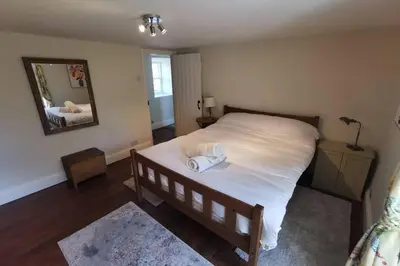 a bedroom with a bed with two towels on it at Cosy, Coastal Retreat with a Large Garden in Monreith