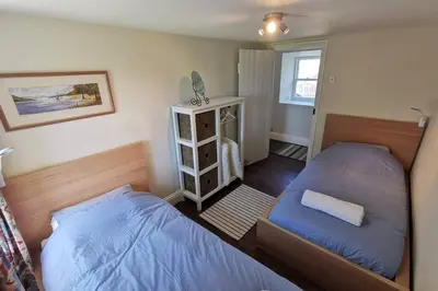 a bedroom with two twin beds and a window at Cosy, Coastal Retreat with a Large Garden in Monreith