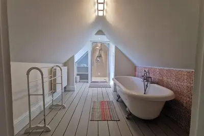 a bathroom with a large bath tub and a sink at Cosy, Coastal Retreat with a Large Garden in Monreith