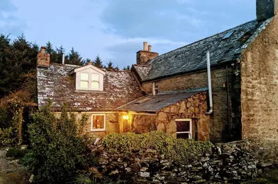 an old stone house with a window on it at Cosy, Coastal Retreat with a Large Garden in Monreith