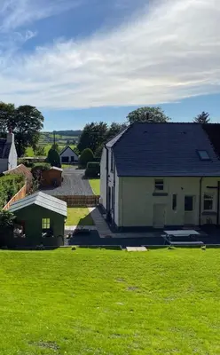 a house with a green field in front of it at 2 Calgow Cottages in Newton Stewart