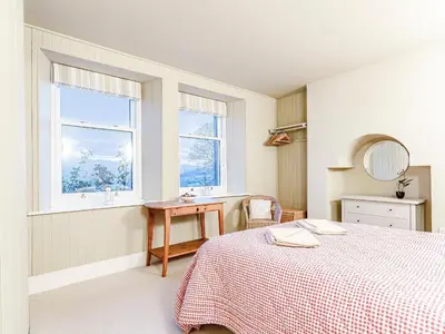 a bedroom with a bed and a desk and a window at Sharrow View in Watermillock