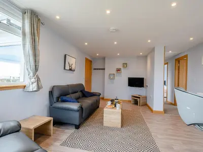 a living room with a couch and a tv at Sand View in Mainsriddle