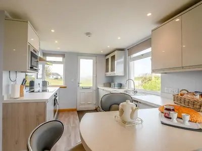 a kitchen with a table and chairs in a kitchen at Sand View in Mainsriddle