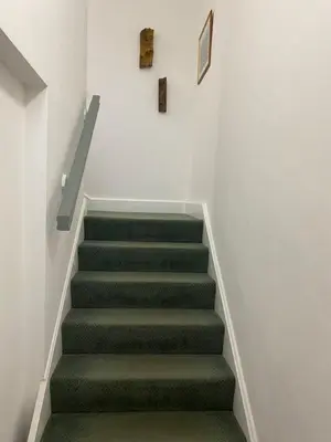 a stairway with green carpeted stairs in a building at Kezbah2 22 the square centre of Dalston village in Dalston