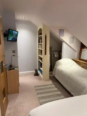 a bedroom with a bed and a tv on the wall at Reayrt Ny Marrey in Kirkmichael