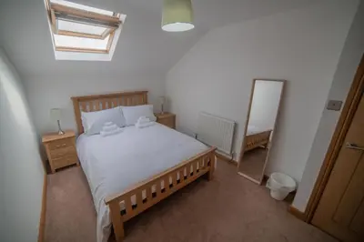 a bedroom with a large bed and a mirror at The Haven Keswick - Spacious Central Apartment in Keswick