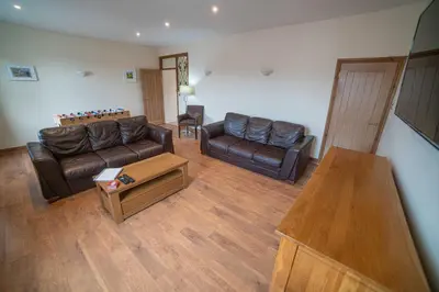 a living room with leather couches and a table at The Haven Keswick - Spacious Central Apartment in Keswick