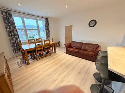a living room with a couch and a dining room table at The Haven Keswick - Spacious Central Apartment in Keswick