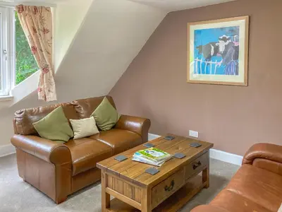 a living room with a couch and a coffee table at The Grooms Cottage in Mauchline