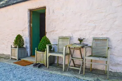 two chairs and a table in front of a building at The Munches Room at Buittle Castle in Castle Douglas