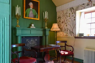 a room with a fireplace and a table and chairs at The Munches Room at Buittle Castle in Castle Douglas